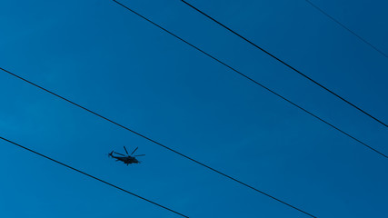Helicopter flying between high tension wires