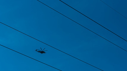 Helicopter flying between high tension wires