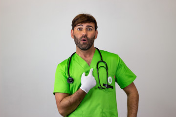 Portrait of male veterinary doctor in green uniform with brown hair insulted, looking at the...