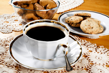 A cup of coffee, lace doily, wooden table, rustic style. Selective focus