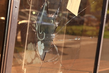 broken glass on shop showcase, vandalism on the street window