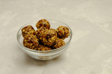 Energy balls - healthy sugarfree fiber-rich snack. Recipe with oats, walnuts, dates and raisins. Image with copy space, selective focus