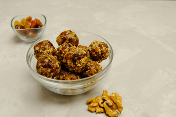 Energy balls - healthy snack rich with fibers and protein. Recipe with oats, walnuts, dates and raisins. Image with copy space, selective focus