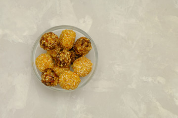 Energy balls made of oats, walnuts, dates and raisins or walnuts, dried apricots and coconut flakes. Image with copy space, selective focus