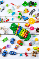 Top view of colorful toys on a wooden white background.