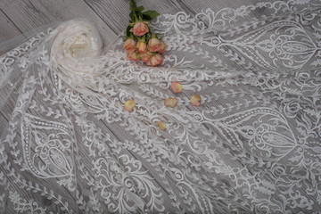 The texture of lace on wooden background decoreted roses.