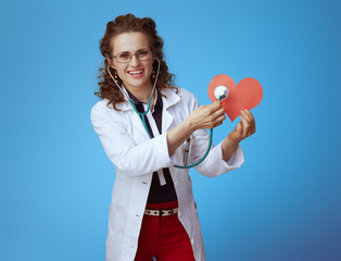 physician woman listening with stethoscope red paper heart