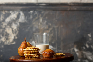 The girl picks up a plastic cup with milk. Breakfast of waffles, fruit, pears and milk. Concept of diet and refusal of milk, celiac disease
