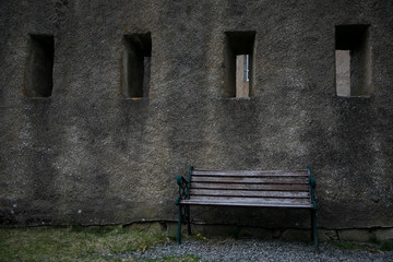Fototapeta na wymiar Old Bench by Stone Wall