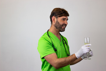 Portrait of male veterinary doctor in green uniform with brown hair at a party, facing forwards and...