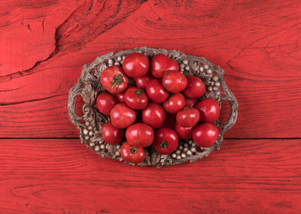 red tomatoes on a vintage tray on a red wooden table