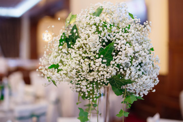 Bouquet of young lilies of the valley on a transparent vase. wed