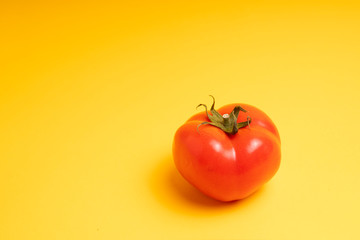 red tomato on a yellow background