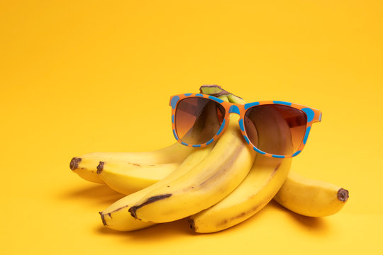 bananas and sunglasses on a yellow background