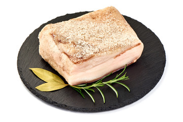 Salted lard on a slate shale plate, preserved pork fat, close-up, isolated on white background