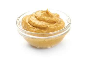 Mustard sauce in bowl, close-up, isolated on white background