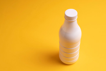 Bottle of milk or kefir on yellow background