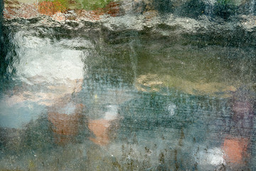 Garden shed closeup on a sunny day with shadows from trees. You see gardening items through the milk glass.