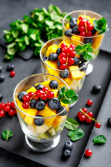 Fresh salad with fruits and berries in glass.