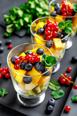 Fresh salad with fruits and berries in glass.