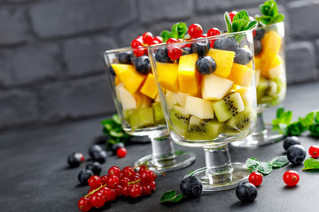 Fresh salad with fruits and berries in glass.