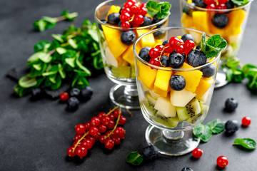 Fresh salad with fruits and berries in glass.