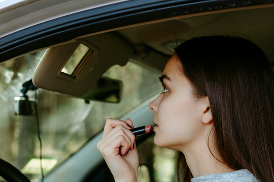 Girl makes up in a car.