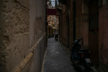 Empty narrow typical for Italy street with motorbikes in Ortigia island in Syracuse, Sicily, south Italy