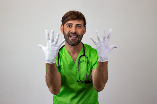 Portrait Of Male Veterinary Doctor In Green Uniform With Brown Hair Holding Up Ten Fingers, Looking At The Camera. Isolated On White Background.