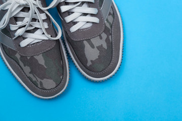 Gray sneakers on a blue background.