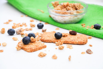 Crunchy muesli cookies and blueberries on green napkin, Breakfast cereals isolated on white background, selective focus, top view