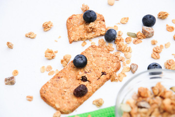 Crunchy muesli cookies and blueberries on green napkin, Breakfast cereals isolated on white background, selective focus, top view