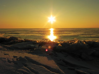 Sunset on the sea in the ice. The sun goes down and illuminates the icy sea, frosty and Sunny,...