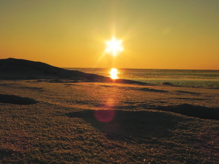 Sunset on the sea in the ice. The sun goes down and illuminates the icy sea, frosty and Sunny,...