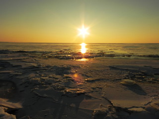 Sunset on the sea in the ice. The sun goes down and illuminates the icy sea, frosty and Sunny,...