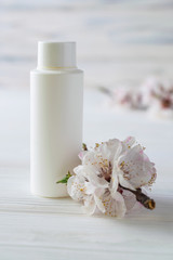 Obraz na płótnie Canvas White body care cosmetics bottle with flowers