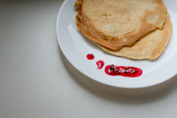 Pancakes with jam on a white plate