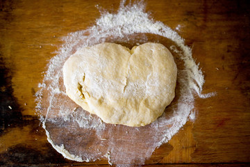 Dough with flour on a wooden table