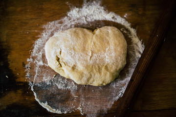 Dough with flour on a wooden table