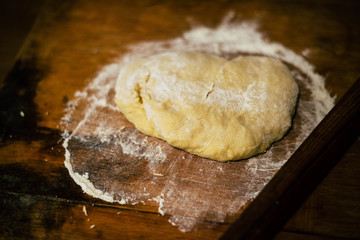 Dough with flour on a wooden table