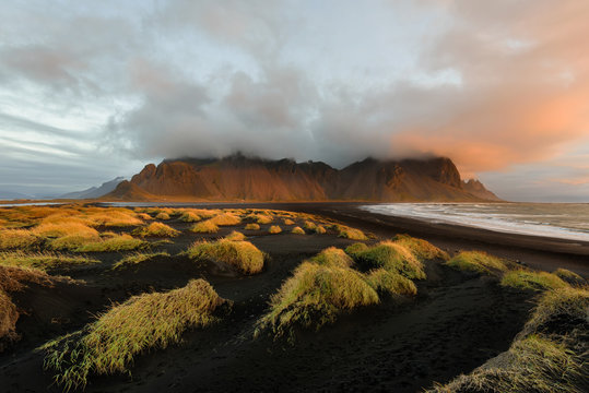 Magical landscape of Vestrahorn Mountains and Black sand dunes in Iceland at sunrise.  Panoramic view of the Stokksnes headland in a Colorfulseascape.
