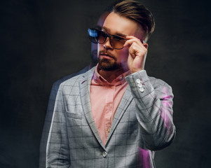Obraz premium Movement photo of attractive smart man in checkered blaze, sunglasses and pink shirt. 