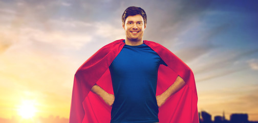 super power and people concept - happy young man in red superhero cape over sunset in city of...