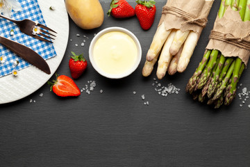 Green and white asparagus with strawberries graphite table