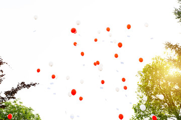 Rote, weiße Luftballons steigen in den Horizont und fliegen in der Luft zum Himmel