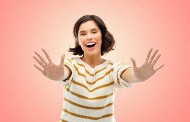 counting and people concept - happy smiling young woman in striped pullover showing ten fingers of two hands over living coral background