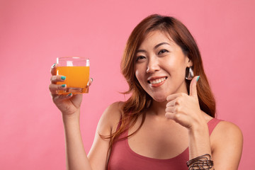 Young Asian woman thumbs up drink orange juice.