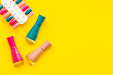 decorative cosmetics set with nail polish and palette for manicure on yellow background top view space for text