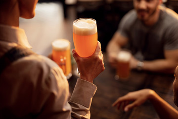 Close up of waitress serving beer to customers in a bar.