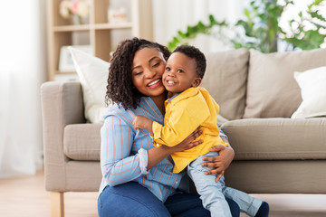 childhood, kids and people concept - happy african american mother with her baby son at home - Powered by Adobe